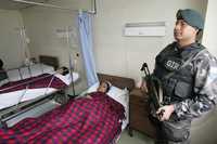 Un oficial de la policía ecuatoriana cuida en un hospital de Quito a las colombianas Diana González (izquierda) y Martha Pérez, heridas el pasado sábado durante el bombardeo del ejército de Colombia contra las FARC. En ese mismo nosocomio está internada la mexicana Lucía Andrea Morett