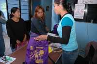 El cabildo de Ecatepec detectó irregularidades en el manejo de los programas de becas y útiles escolares del ayuntamiento, por lo que pidió que se realice una auditoría. El director de educación dimitió al enterarse de la decisión. En la imagen, correspondiente a 2007, empleadas del gobierno municipal entregan mochilas, cuadernos y otros artículos a una de las beneficiarias